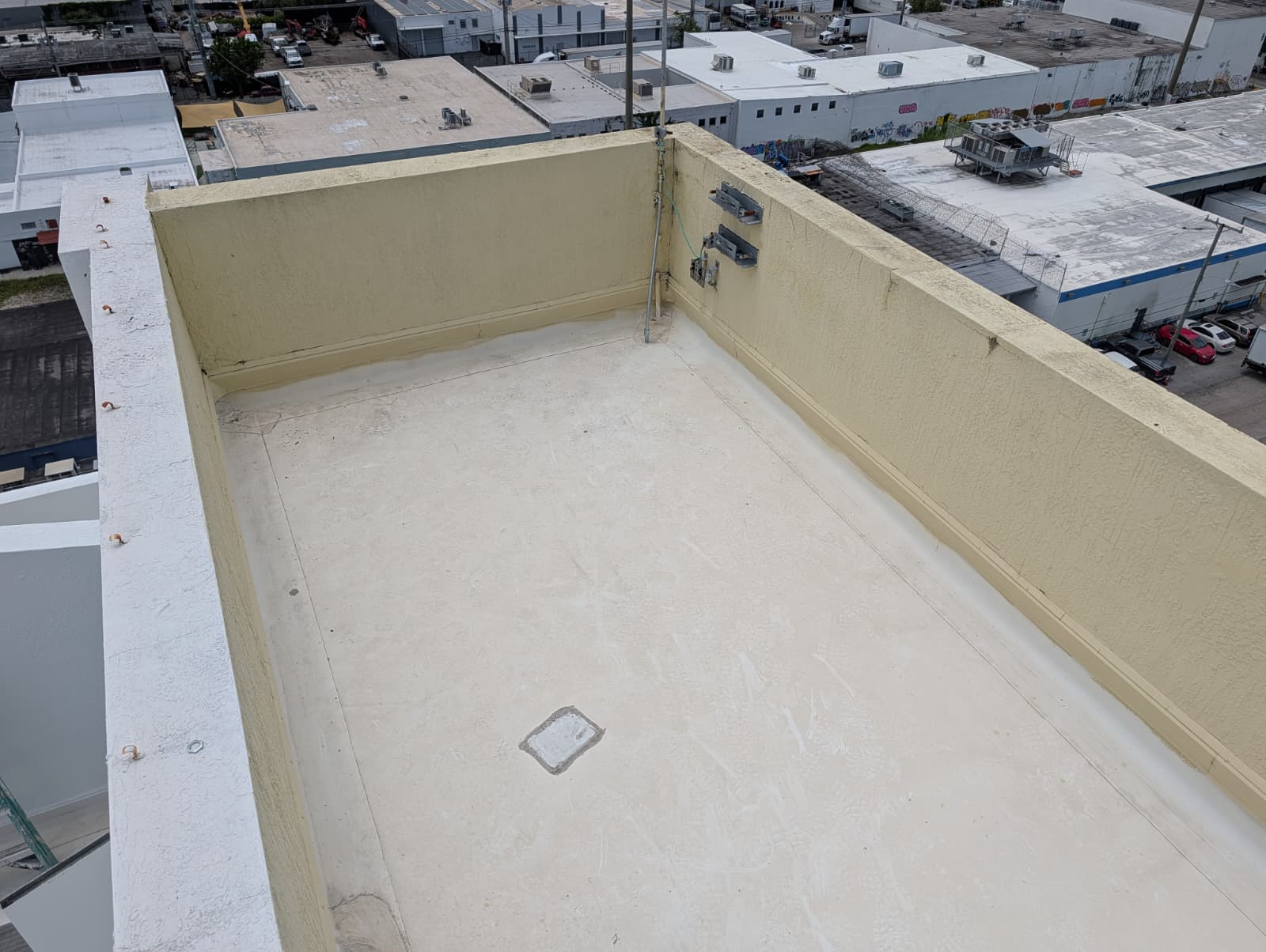 Commercial rooftop deck waterproofing and structural stucco parapet wall restoration in South Florida
